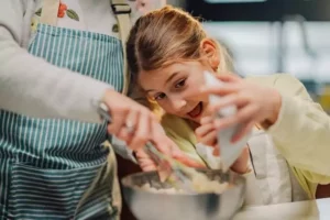 une enfant et sa maman préparent des cookies de Noel avant de les décorer, une animation vacances de Noël et d'hiver proposée par Family Ecolodge Puisaye