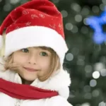 une enfant avec un bonnet de Père Noël, venue fêter Noël en famille à Family Ecolodge Puisaye