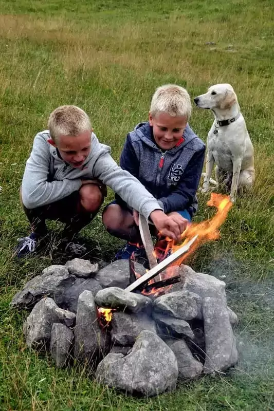 2 enfants font un feu de camp pendant leurs vacances d'été loin de la foule à Family Ecolodge Puisaye