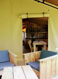 Gros plan sur l'alliance de la toile robuste et du bois massif, l'essence même de l'expérience glamping authentique et confortable de notre Safari Lodge.