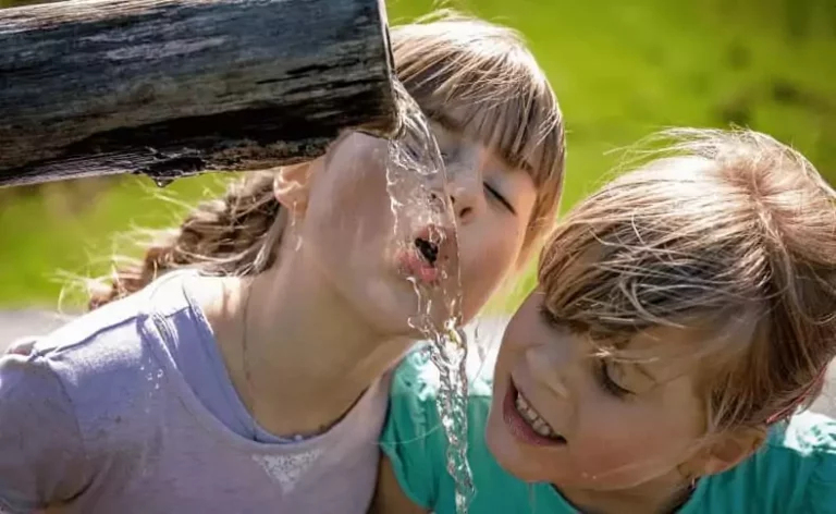 vacances écologiques en famille : des enfants boivent à la fontaine, vacances nature