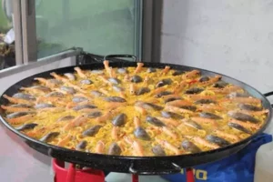 une paella géante cuisinée devant vous chez Family Ecolodge Puisaye, le gîte de groupe en pension complète entre Paris et Lyon