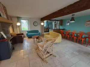 le séjour avec cheminée et rocking-chair de de Family Ecolodge Puisaye, ouvert toute l'année