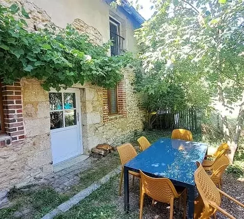 Façade du gîte Le Logis au Family Ecolodge Puisaye entouré de verdure, un déjeuner à l'ombre des arbres