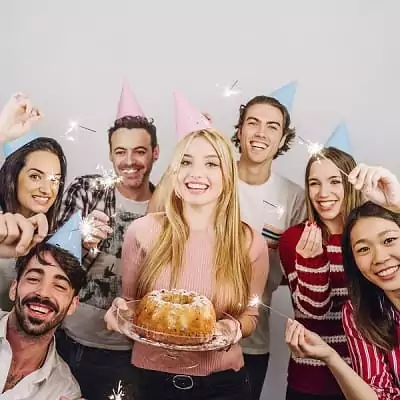 une jeune femme entourée de ses amis pour fêter son repas d'anniversaire original
