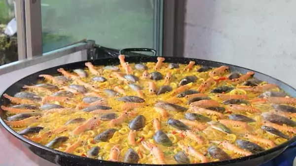 une paella géante cuisinée devant vous pour votre repas d'anniversaire original