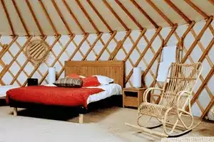 le lit en bois de la yourte Faucon, dormir dans une yourte chez Family Ecolodge Puisaye pour des vacances insolites et écolos en famille