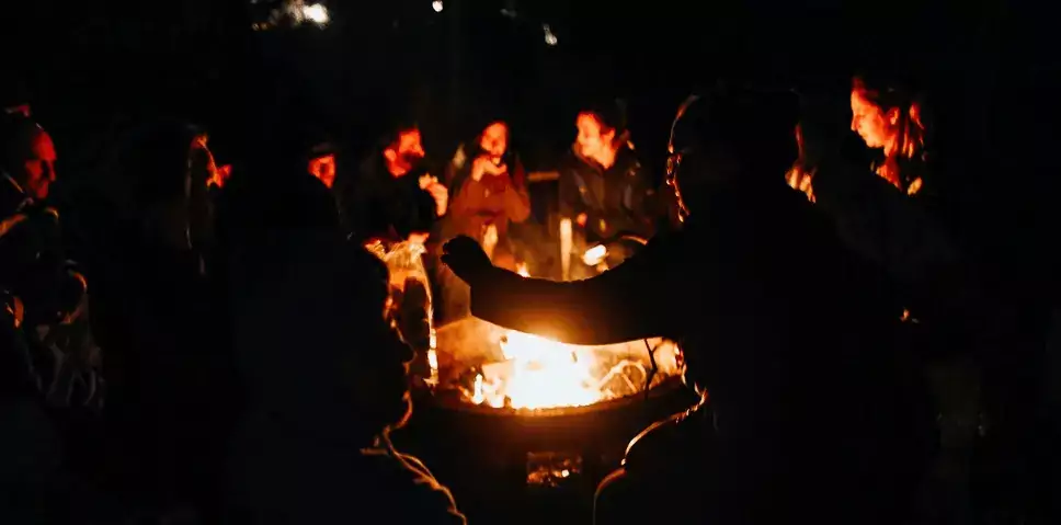 des personnes discutent autour d'un feu de camp, ils se sont connus pendant leurs vacances insolites et écologiques ou un WE entre amis original à Family Ecolodge Puisaye