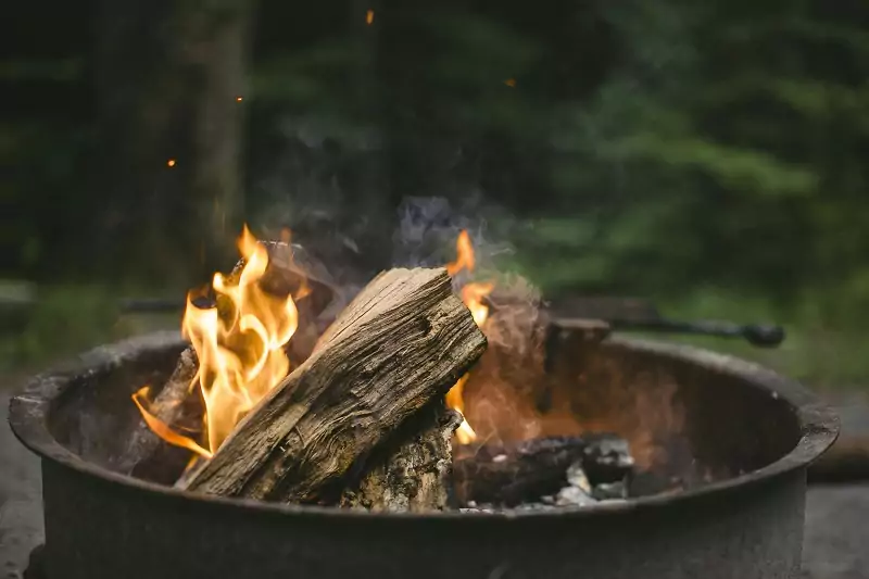 un feu de bois brûle dans un brasero dans une ambiance cocooning en hiver