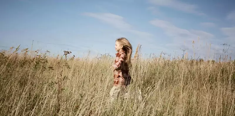 un enfant court dans une prairie de campagne