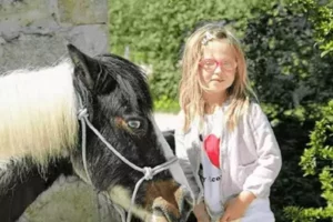 une enfant tient un poney, une animation vacances gratuite de Family Ecolodge Puisaye