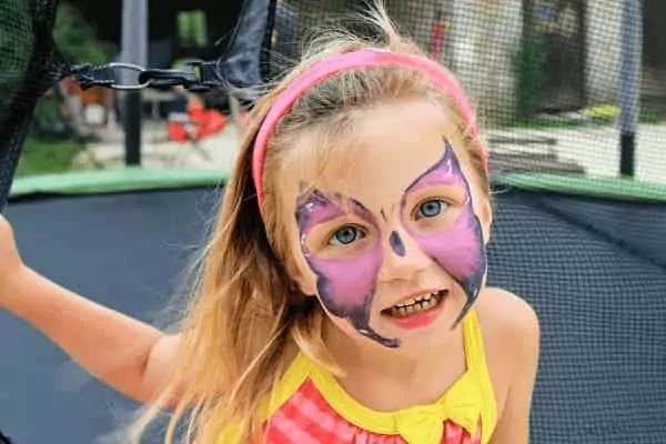 une enfant a le visage maquillé, un beau papillon, une animation vacances gratuite de Family Ecolodge Puisaye