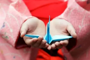 une enfant montre l'origami qu'elle a fabriqué, une animation vacances gratuite de Family Ecolodge Puisaye