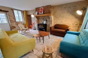 le séjour avec cheminée du gite le Logis, chez Family Ecolodge Puisaye