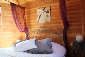 le lit à baldaquins de la cabane perchée dans les arbres écureuil, chez Family Ecolodge Puisaye