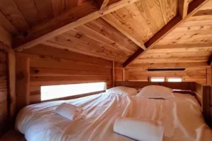 le lit parental de la cabane perchée dans les arbres de Family Ecolodge Puisaye les 3 Chouettes