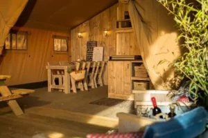 l'intérieur de la tente safari de Family Ecolodge Puisaye, avec la salle à manger et le séjour