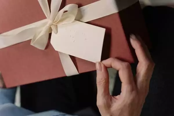 une personne ouvre son cadeau, elle a reçu un bon cadeau séjour de Family Ecolodge Puisaye