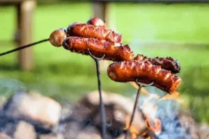 Des saucisses grillées par un couple en WE à Family Ecolodge Puisaye