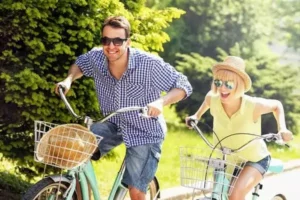 Un couple fait la course à vélo, des vélos que l'on peut louer pour des vacances en amoureux à Family Ecolodge Puisaye