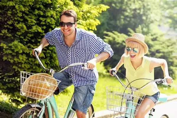 Un couple fait la course à vélo, des vélos que l'on peut louer pour des vacances en amoureux à Family Ecolodge Puisaye