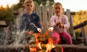 des enfants font un feu de camp & grillent des chamallows au cours de leur séjour insolite à Family Ecolodge, pour le nouvel an en famille