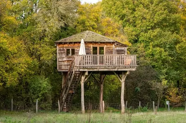 une cabane perchée dans les arbres aux couleurs de l'automne, dormir dans les arbres toute l'année.