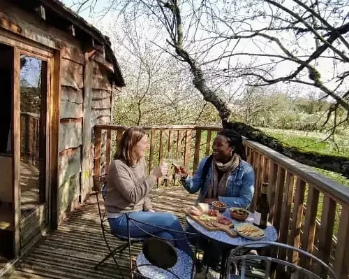 un apéritif sur la terrasse de la cabane perchée dans les arbres de Family Ecolodge Puisaye