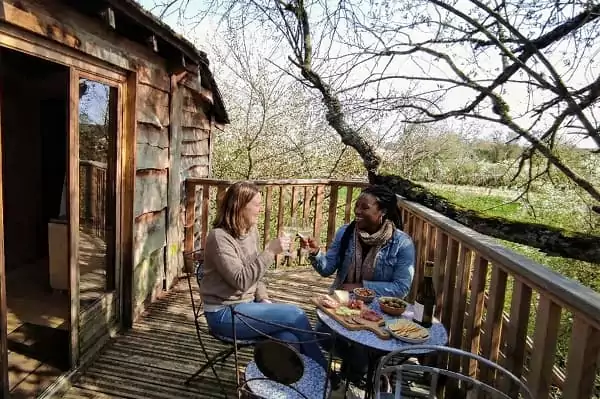 un apéritif sur la terrasse de la cabane perchée dans les arbres de Family Ecolodge Puisaye