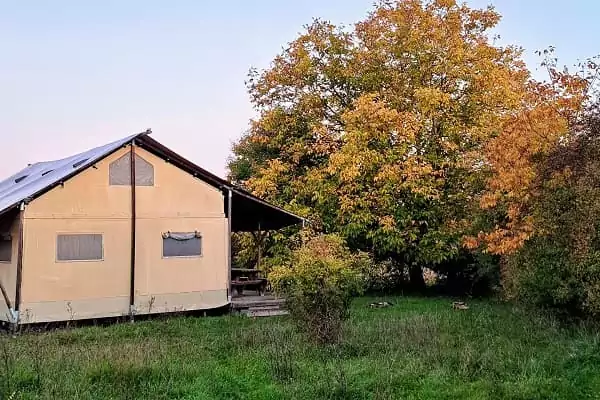 Une tente safari lodge au coucher du soleil, une location du guide complet de l'hébergement insolite de Family Ecolodge Puisaye