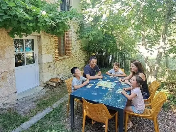 une famille joue à un jeu de société pendant ses vacances écologiques.