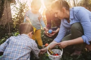 une famille, maman et enfants, cherchent des oeufs pendant la chasse aux oeufs de Pâques de Family Ecolodge Puisaye