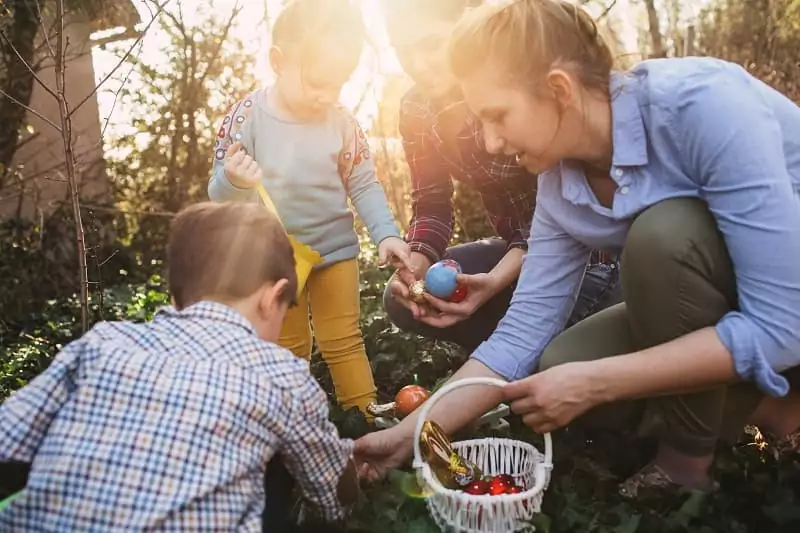 une famille, maman et enfants, cherchent des oeufs pendant la chasse aux oeufs de Pâques de Family Ecolodge Puisaye