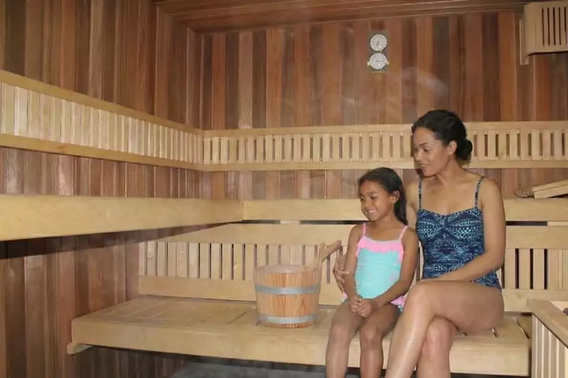 une maman et sa fille profitent d'une séance de sauna, ambiance cocooning pour des vacances maman solo à Family Ecolodge Puisaye