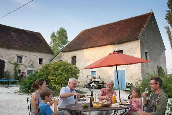 une famille partage un apéritif et se retrouve pour un week-end intergénérationnel au cœur de la nature, à Family Ecolodge Puisaye