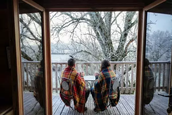 Un couple savoure un chocolat chaud dans leur cabane perchée à Family Ecolodge