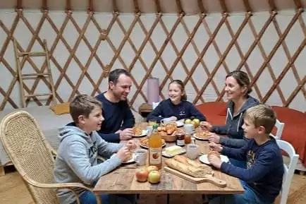 une famille mange son petit-déjeuner dans la convivialité.