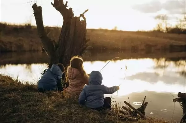 des enfants pêchent dans un étang, une idée de sortie en famille pour les vacances de février
