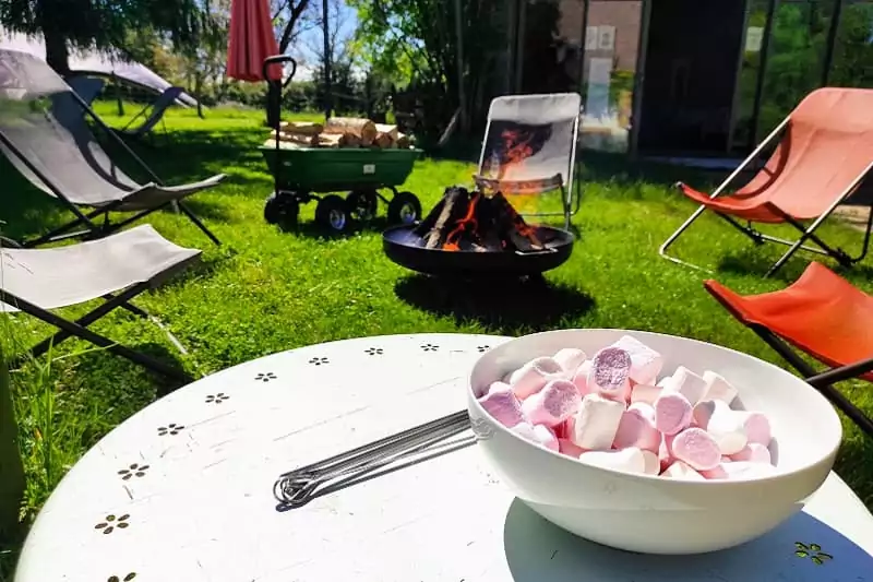 Des marshmallows et un feu de camp dans la coure de Family Ecolodge.