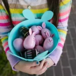 une enfant avec des oeufs décorés pendant le week-end de Pâques