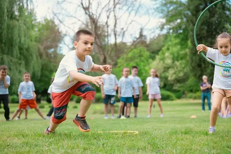 des enfants en vacances à Family Ecolodge font une course de relais pendant l'animation vacances olympiades