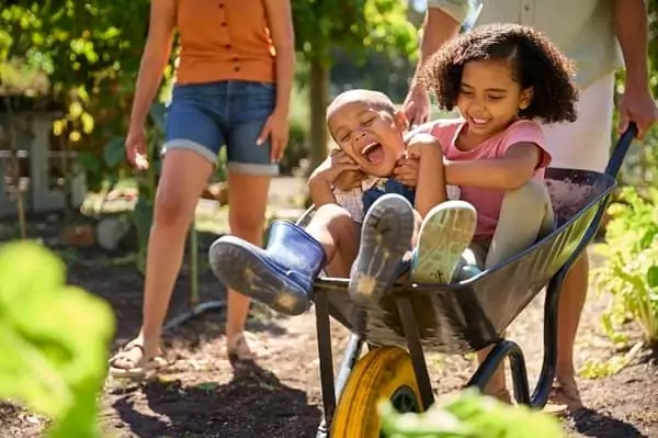 Des enfants jouent dans une brouette avec leurs parents, au cours d'un week-end de Pâques en famille
