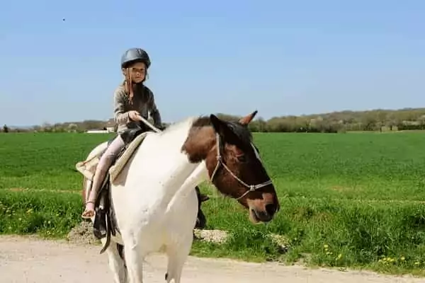 un enfant sur un cheval pour un baptême pendant son WE de Pâques