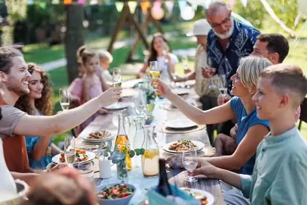 Une famille nombreuses est regroupée autour d'un repas, durant un week-end de groupe à Family Ecolodge, en région Centre Val de Loire.