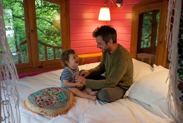 un papa et son enfant en bas âge dans une roulotte Family Ecolodge Puisaye