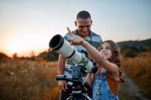un papa et sa fille observent les étoiles pendant leurs vacances dépaysantes à moins de 2h de Paris