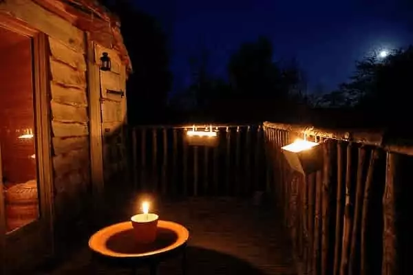 une cabane dans les arbres de nuits avec des bougies pour des vacances en famille 100% originales