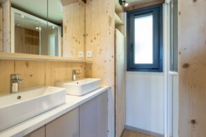salle de bain du lodge insolite au milieu d'une prairie verte au printemps.